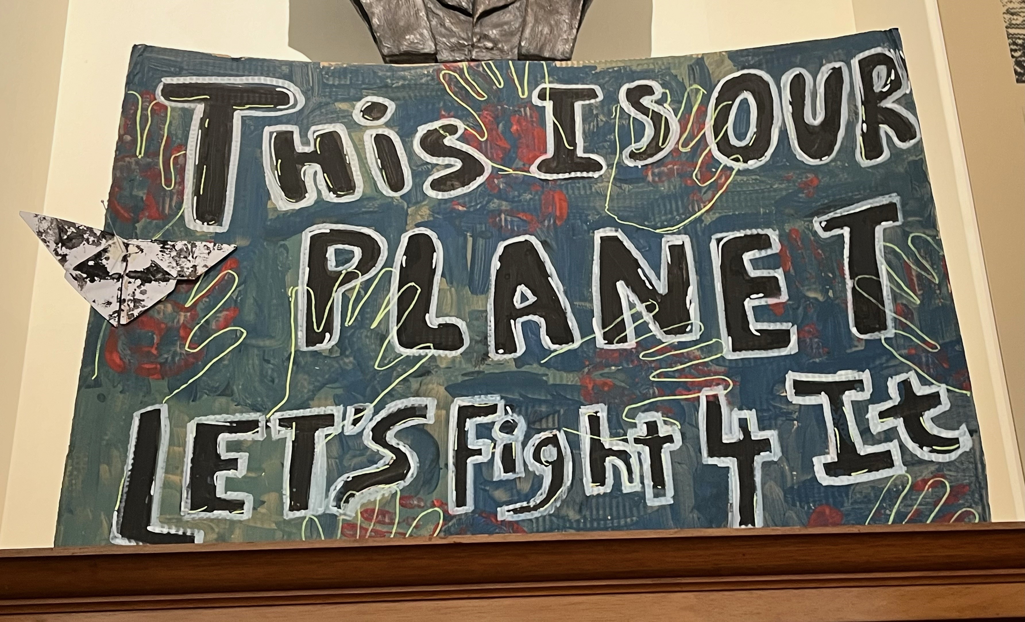 A home-made climate protest banner stating 'this is our planet, let's fight 4 it'