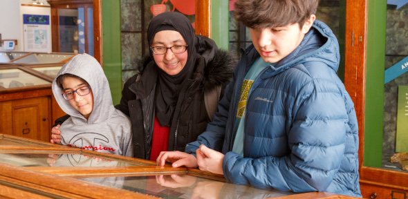 Woman and two children looking in a museum case