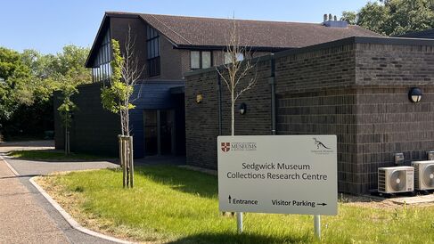 sign reading Sedgwick Museum Collections Research Centre in front of a large dark grey building with green grass in front