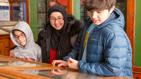 Woman and two children looking in a museum case